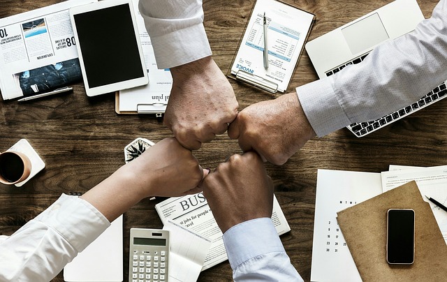 four hands connect in fist bump